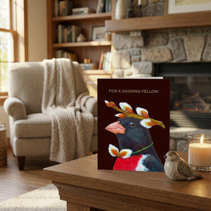 Greeting card with a crowned bird on a table, cozy room, stone fireplace, and an armchair.