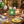 Table with colorful plates, cake slices, lit candles, balloons, confetti, and a birthday card.