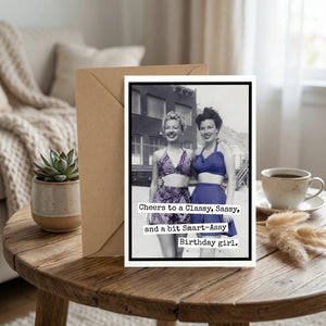Vintage photo card with two women in swimsuits on a table, text: "Cheers to a Classy, Sassy Birthday girl."