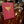 Pink card with a gold martini glass on a wooden bar, with blurred patrons in the background.