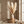 Pampas grass in a textured vase on a wooden stand, with neutral tones and soft natural light.