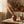Rustic vase with pampas grass on a wooden table, warm tones, basket, and autumn leaves.