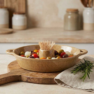Olives and cherry tomatoes in a tan dish with toothpicks, on a wooden board, rosemary on cloth.