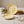 Yellow plaid ceramic plates on a beige tablecloth with crackers and green leaves on a wooden board.