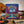 Colorful book cover with a winged skull, roses, and psychedelic patterns; guitar and records nearby.
