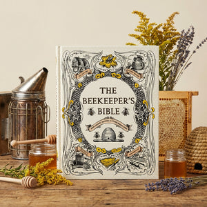 A decorative book titled "The Beekeeper's Bible" surrounded by honey, flowers, and beekeeping tools.