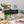 Coloring book with vibrant floral patterns on a desk, surrounded by colored pencils and markers.