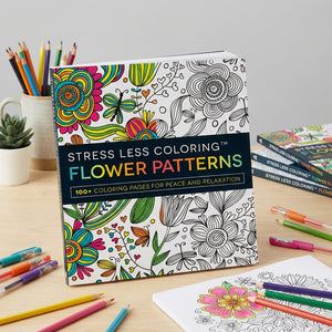 Coloring book with vibrant floral patterns on a desk, surrounded by colored pencils and markers.