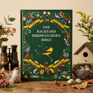 Open book titled The Backyard Birdwatcher's Bible by Abrams, featuring colorful bird illustrations and identification tips.
