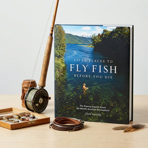 Open book titled "Fifty Places to Fly Fish Before You Die" by Abrams, featuring scenic fly fishing destinations on the pages
