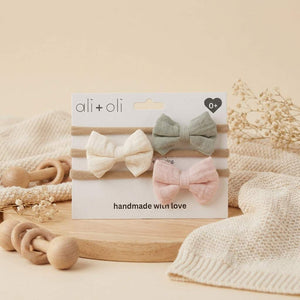 Cream baby headband bow set by Ali+Oli, featuring soft fabric and adjustable elastic for a cute, comfortable baby accessory.