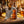 Fish-shaped bottle opener on a beer bottle, surrounded by lemons and drinks on a wooden table.