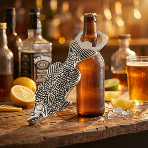 Fish-shaped bottle opener on a beer bottle, surrounded by lemons and drinks on a wooden table.