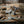 Whale tail sculptures on rustic wood table with seashells, driftwood, rope, and fishing net.