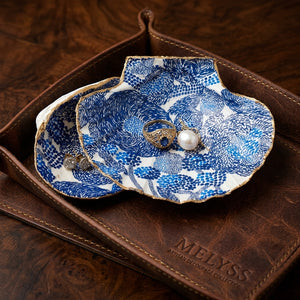 Handmade blue swirl painted shells from PEO, featuring intricate designs and vibrant colors, displayed on a neutral background.