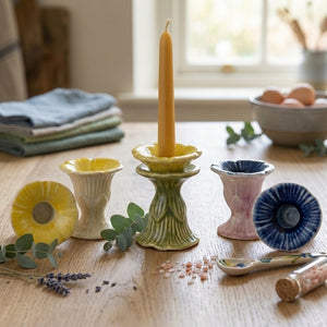 Stoneware flower-shaped taper candleholder in three styles by CCOI, featuring intricate floral designs and a sturdy base.
